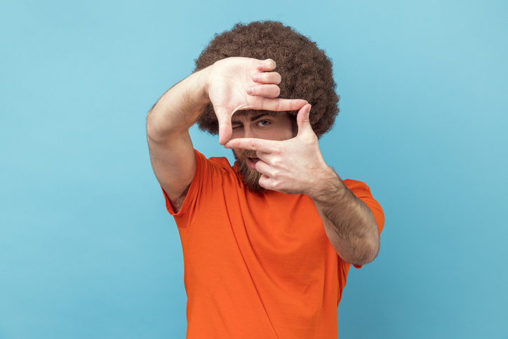 Man looking through fingers making camera gesture, camera men looking for properly focus